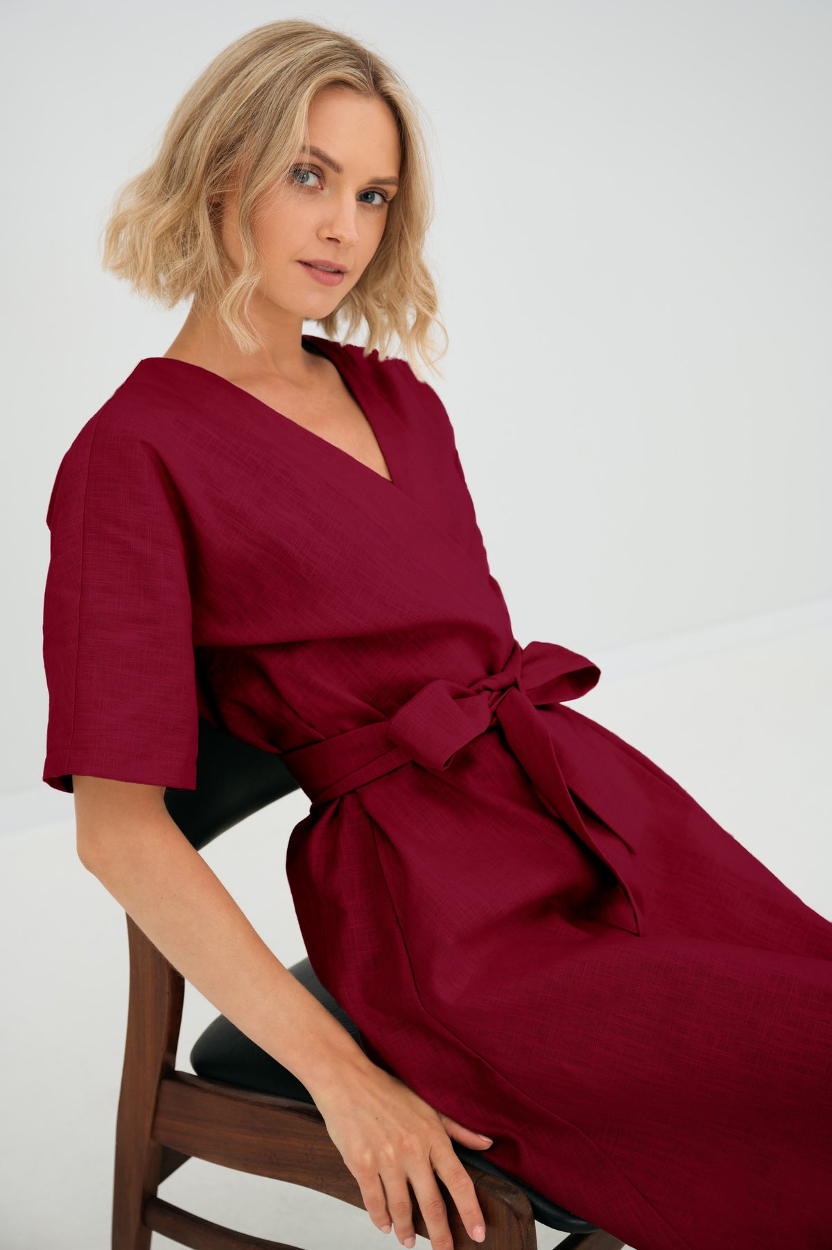 LeMuse CHLOE linen dress in cerise – seated close-up, bow detail #Color_Cerise