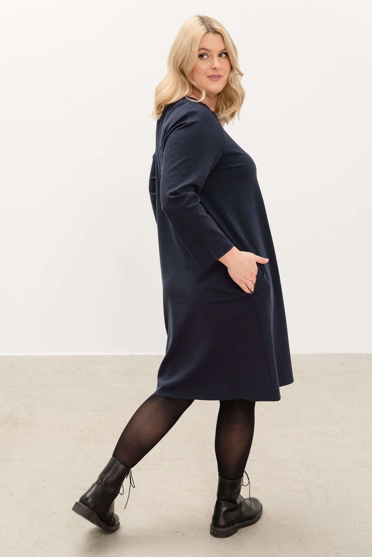 FRENCH – Italian Punto Milano Ribbon Neck A-Line Dress – deep blue dress, side view in motion with a hand in the side pocket #Color_Deep blue