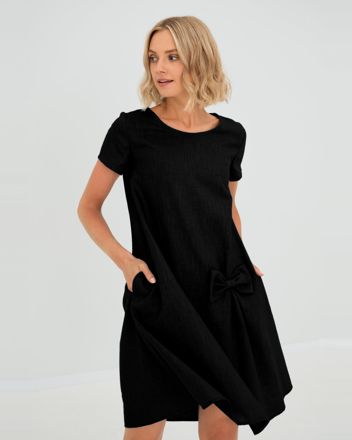 LeMuse SUMMER KISS linen dress in black – studio front view, hand in pocket #Color_Black