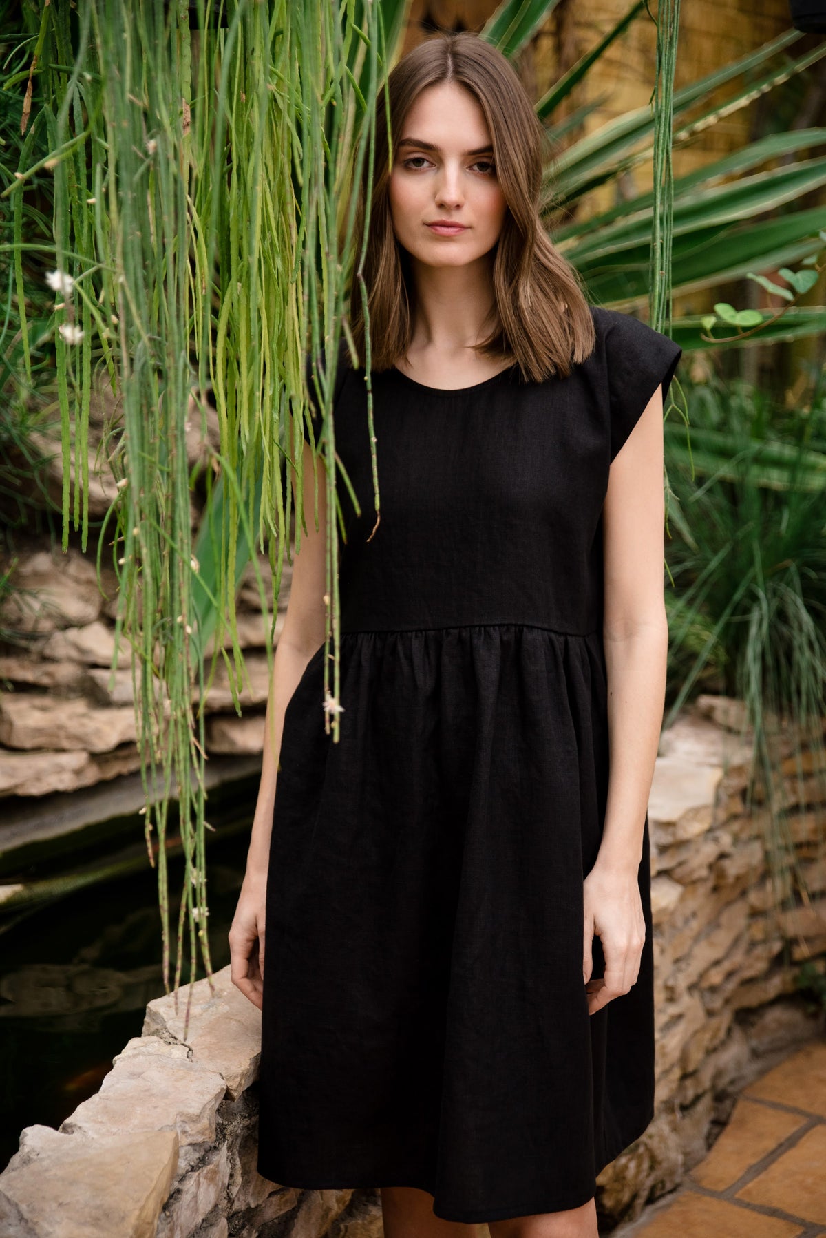 LeMuse LUNA linen dress in black – front in greenhouse #Color_Black
