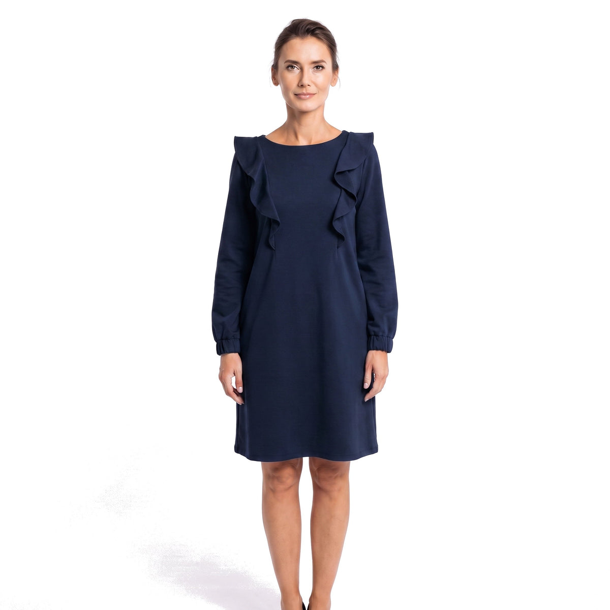 A woman modeling a navy blue knee-length dress with long sleeves, ruffled detailing on the shoulders, and a boat neckline against a plain white background.