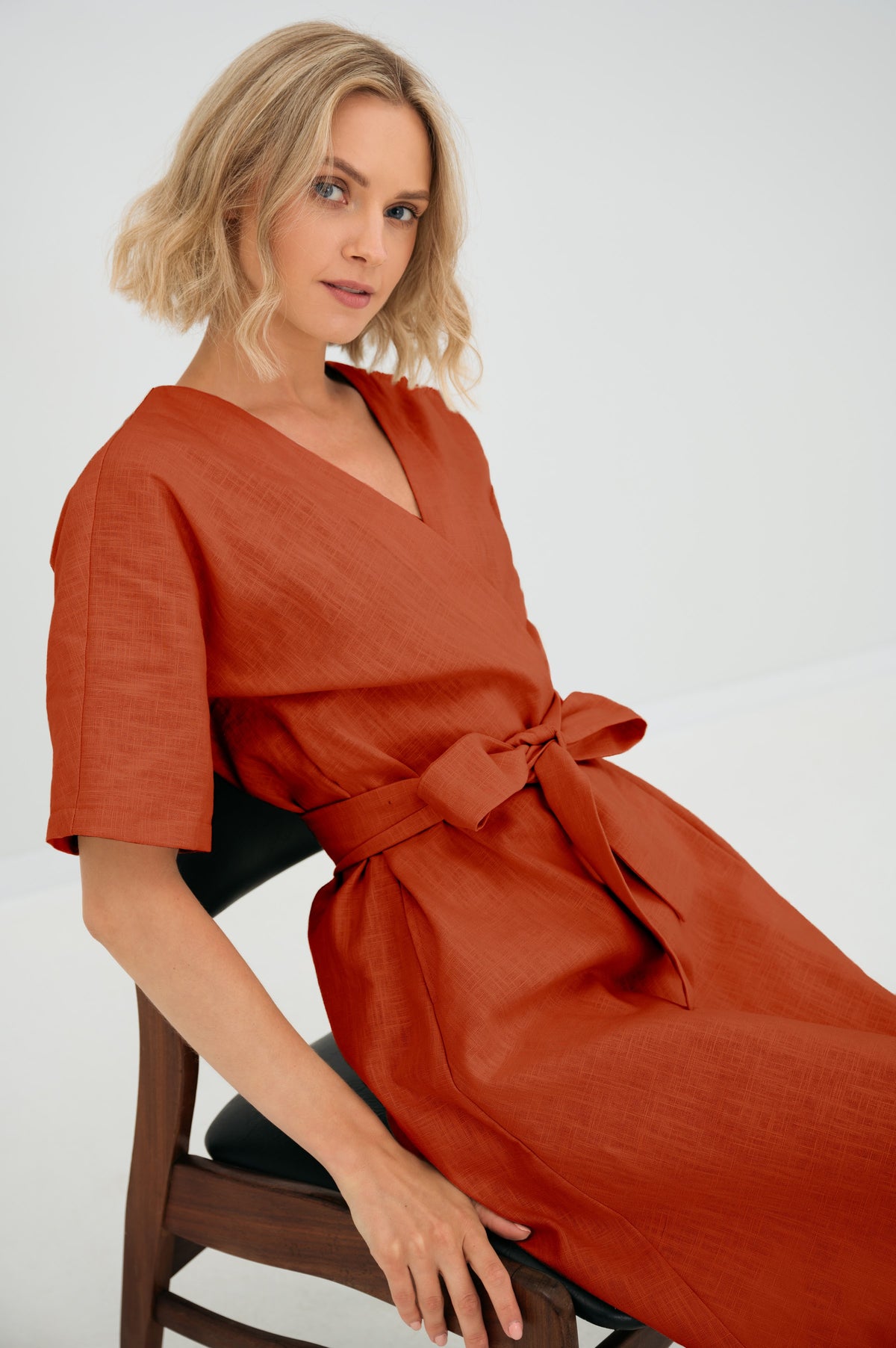 LeMuse CHLOE linen dress in orange – seated close-up, bow detail #Color_Orange