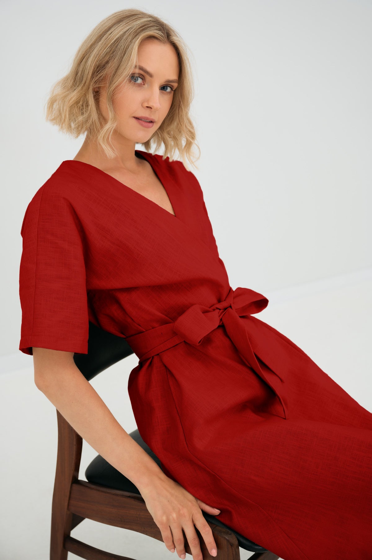 LeMuse CHLOE linen dress in red – seated close-up, bow detail #Color_Red