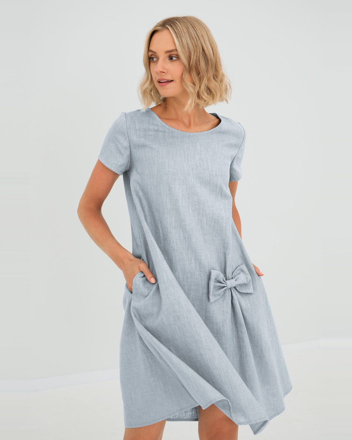 LeMuse SUMMER KISS linen dress in light blue – studio front view, hand in pocket #Color_Light blue