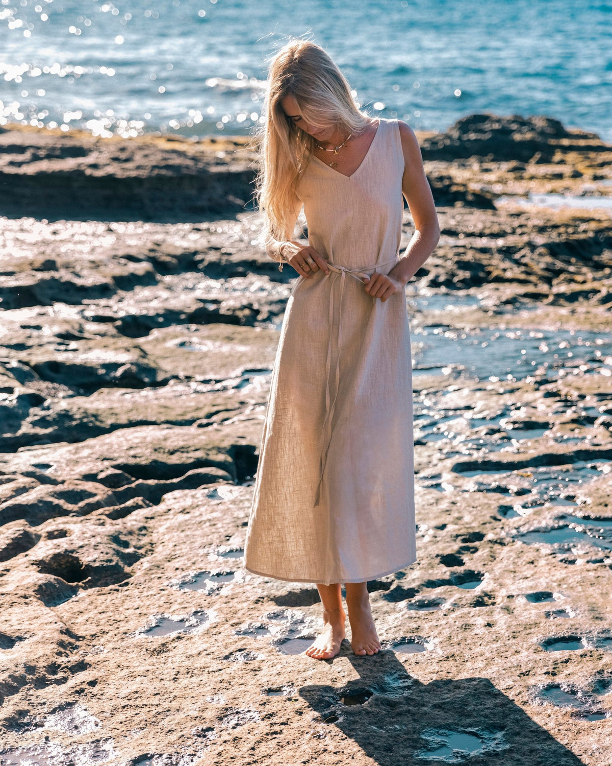 LeMuse SUNSET linen dress in beige – model walking by the sea #Color_Beige