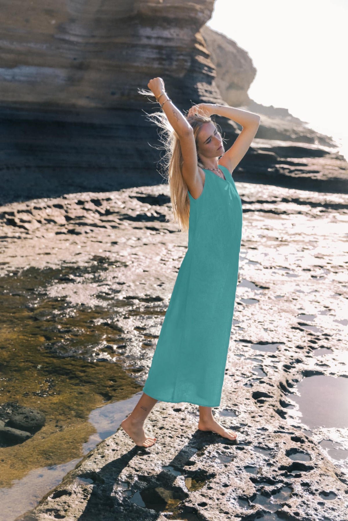 LeMuse SUNSET linen dress in teal – model in motion with arm raised #Color_Teal